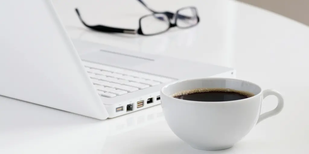 Scrivania in ufficio privato coworking a Pescara con computer portatile e tazza di caffè