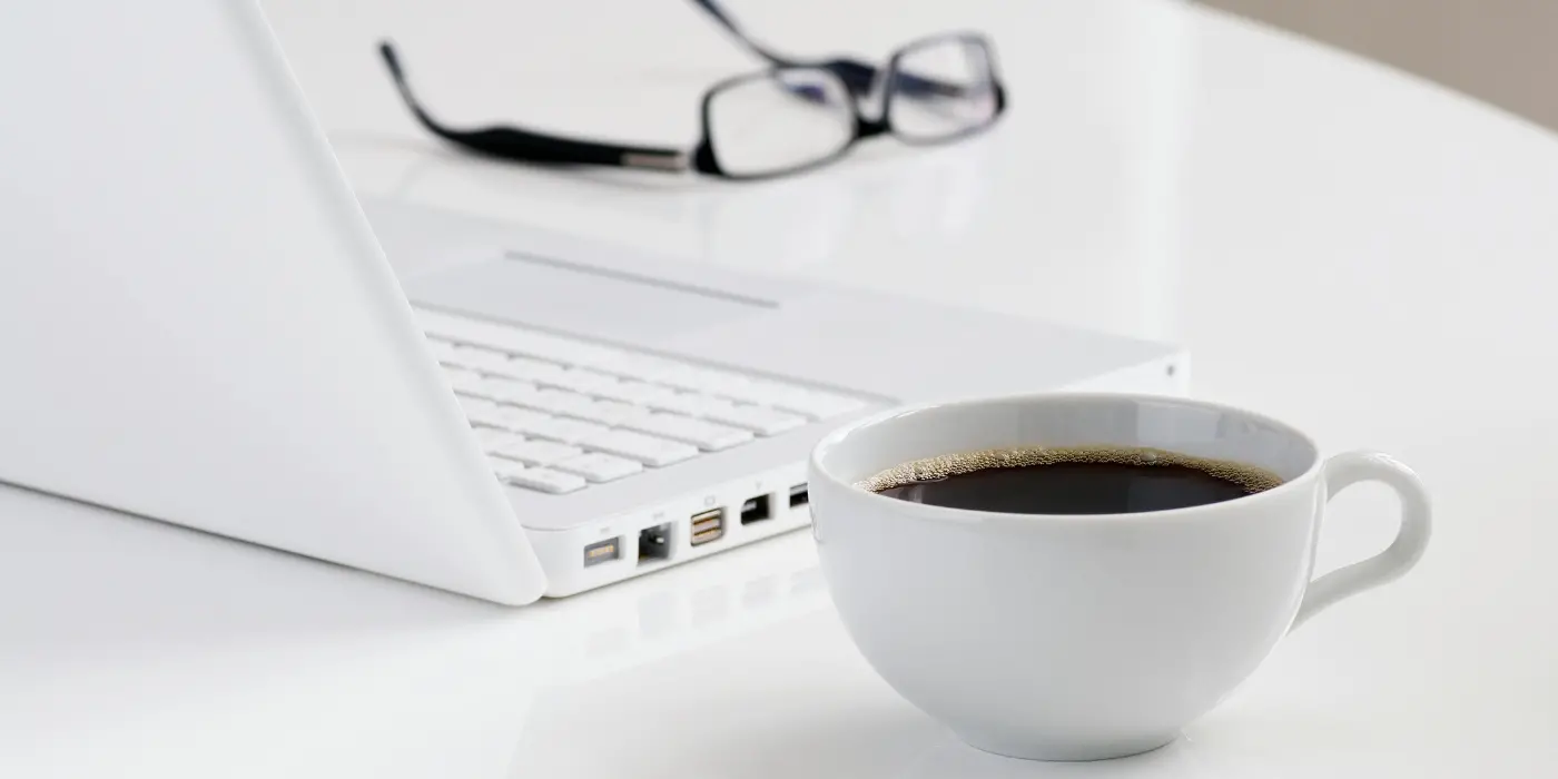 Scrivania in ufficio privato coworking a Pescara con computer portatile e tazza di caffè